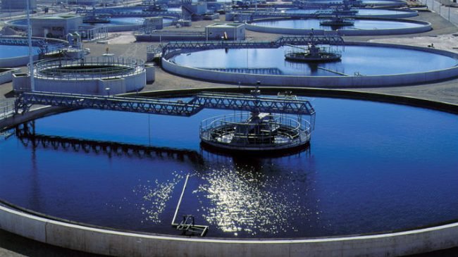 Planta de tratamiento de aguas residuales con tanques circulares de sedimentación.